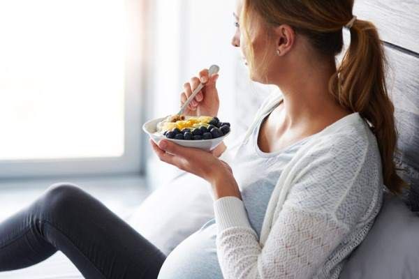 femme enceinte prenant son petit-déjeuner