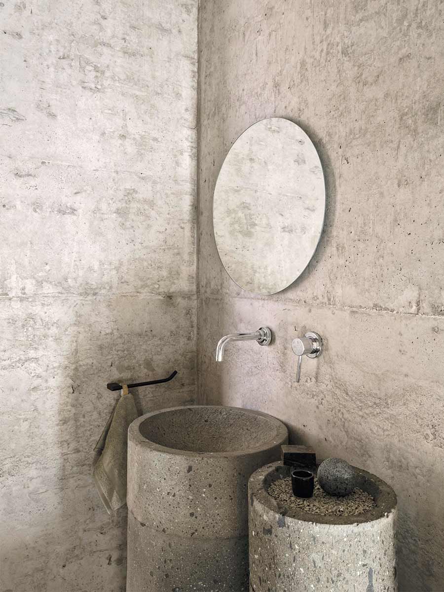 salle de bain avec murs en béton et lavabos en pierre
