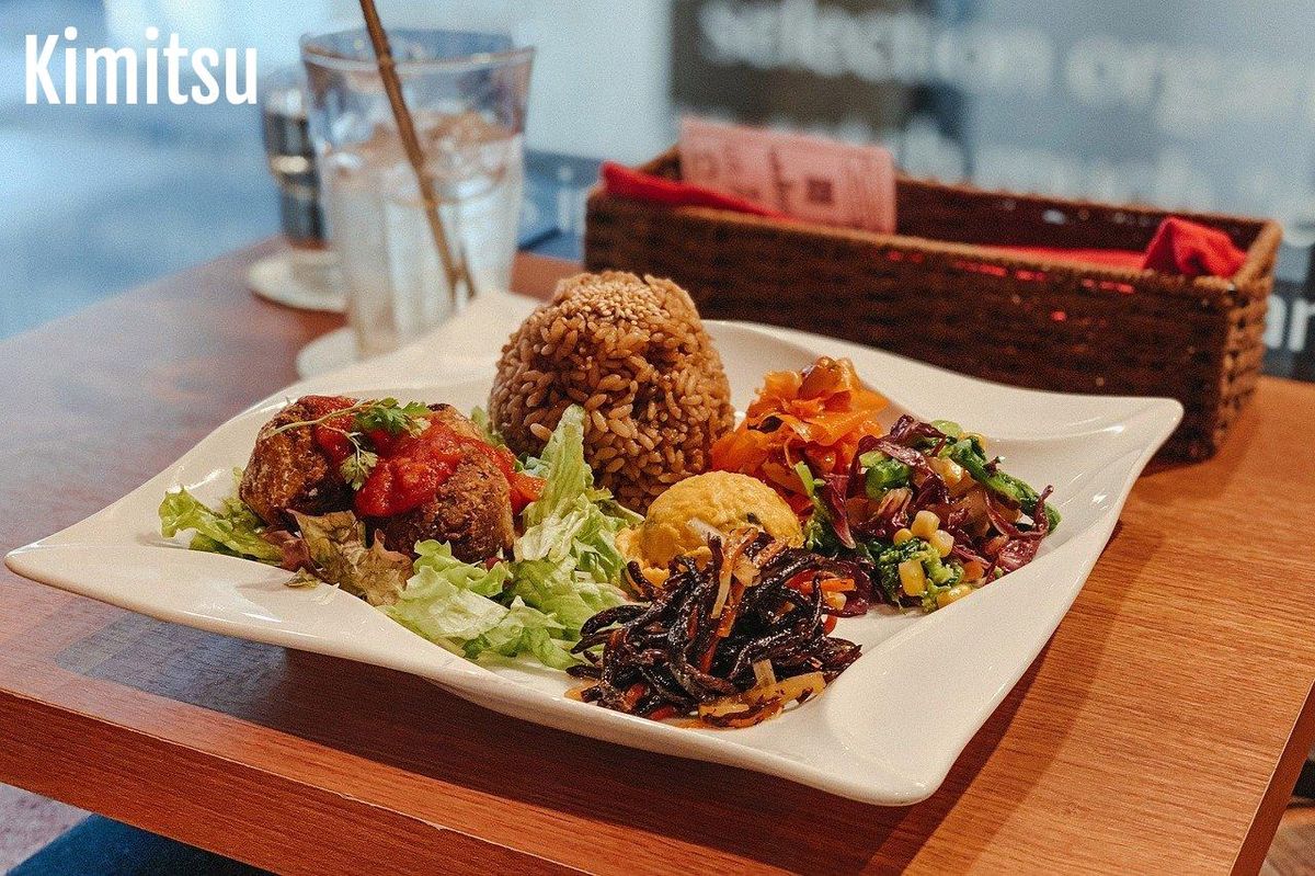 Assiette vibrante pour un déjeuner sain: falafels, riz et salades colorées.