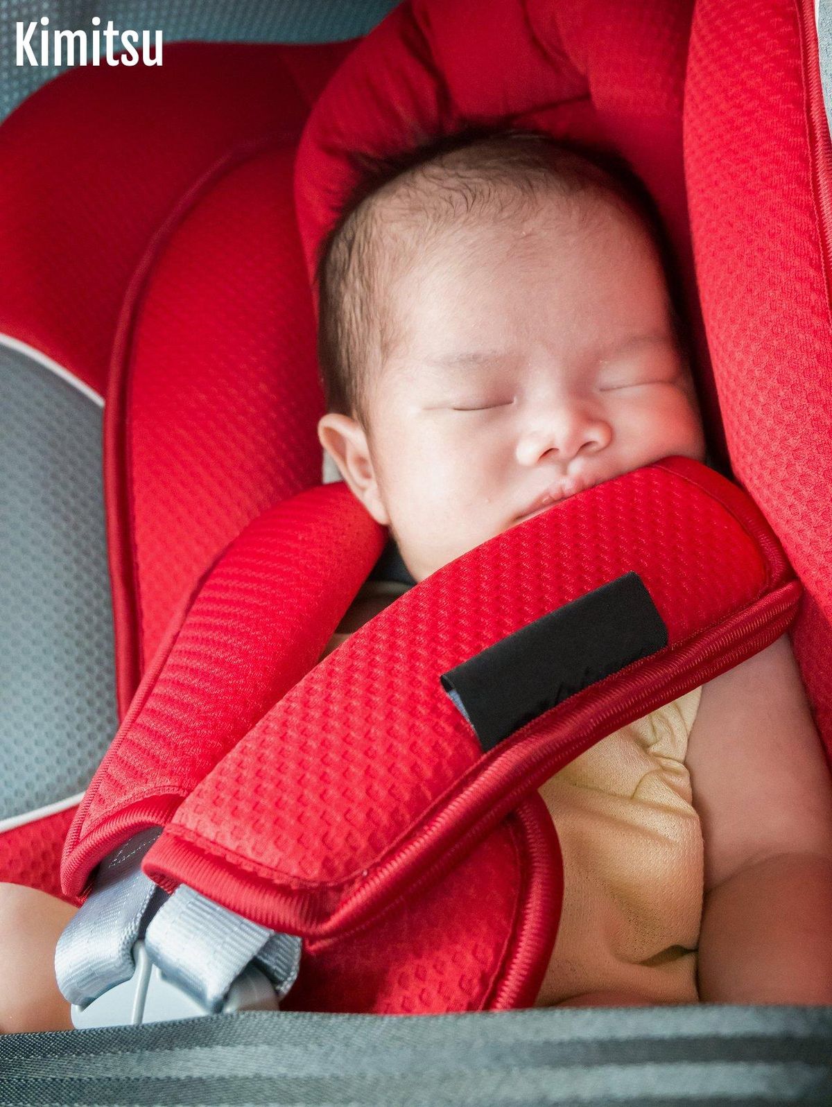 Bébé calmé dans son siège auto avec miroir et jouets pour des trajets en voiture apaisés.