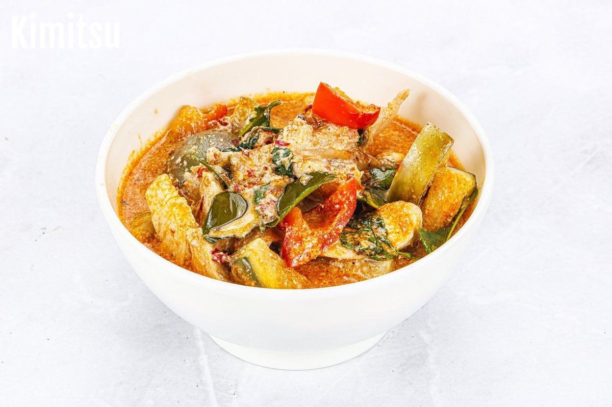 Bol de curry rouge thaïlandais, riche en saveurs aromatiques et légumes colorés.