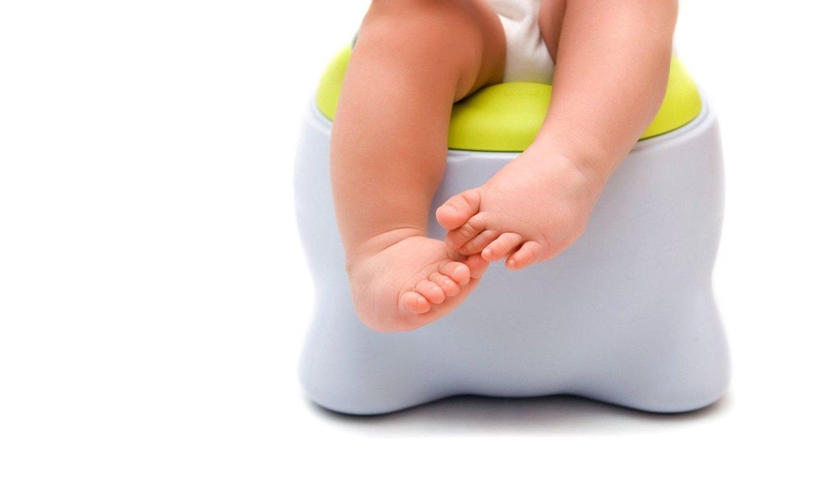 Enfant assis sur un pot dans une salle de bain aménagée, facilitant l'apprentissage de la propreté en douceur.