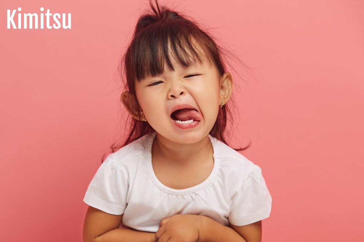 Parent calme parlant à son enfant en pleine crise de tantrum, illustrant la gestion du terrible two.