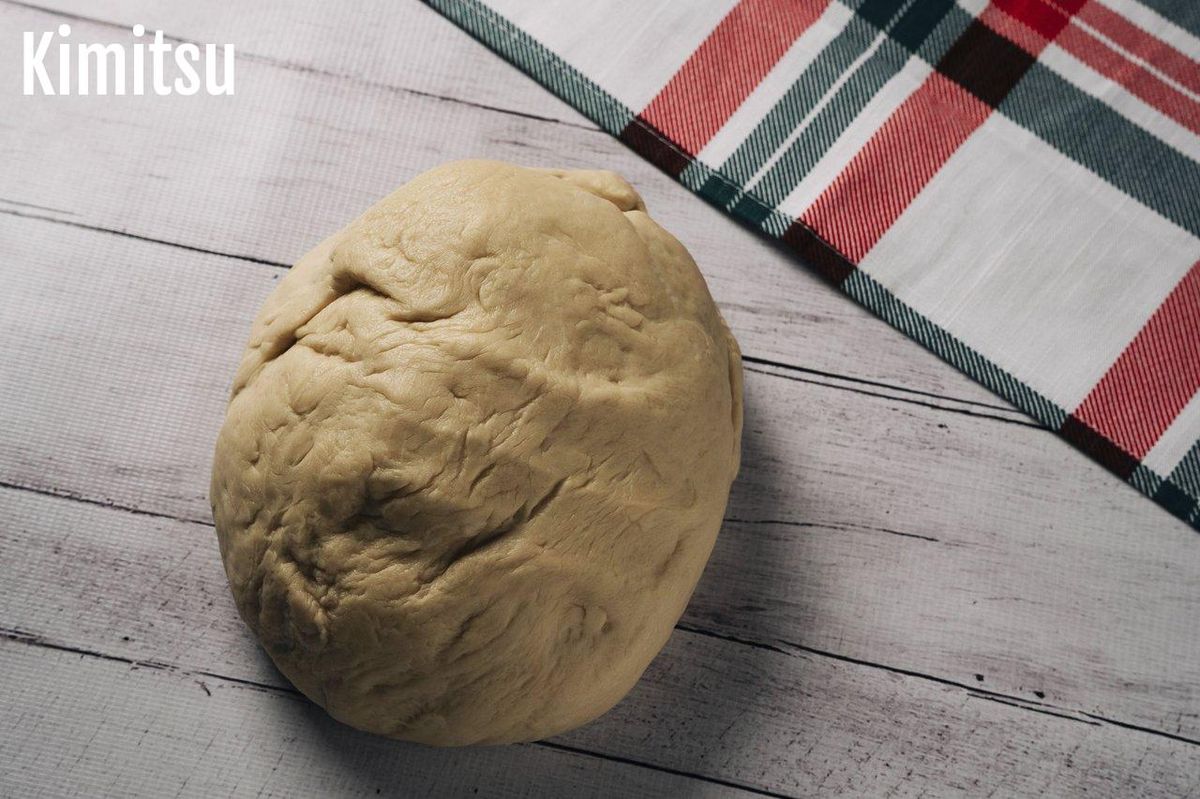 Pâte à pizza maison bien levée et alvéolée, prête à être étalée pour une pizza croustillante et moelleuse.