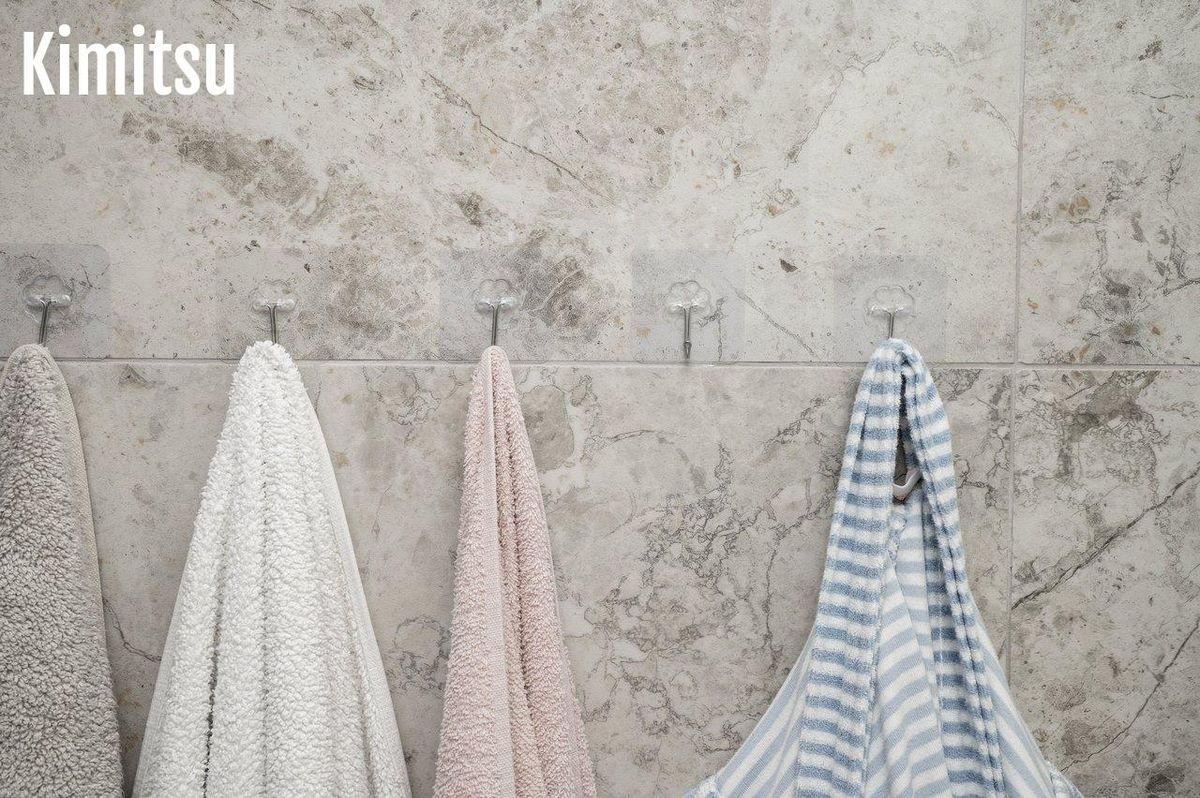 Serviettes de bain suspendues dans une salle de bain lumineuse, offrant une touche d'hygiène et de confort.