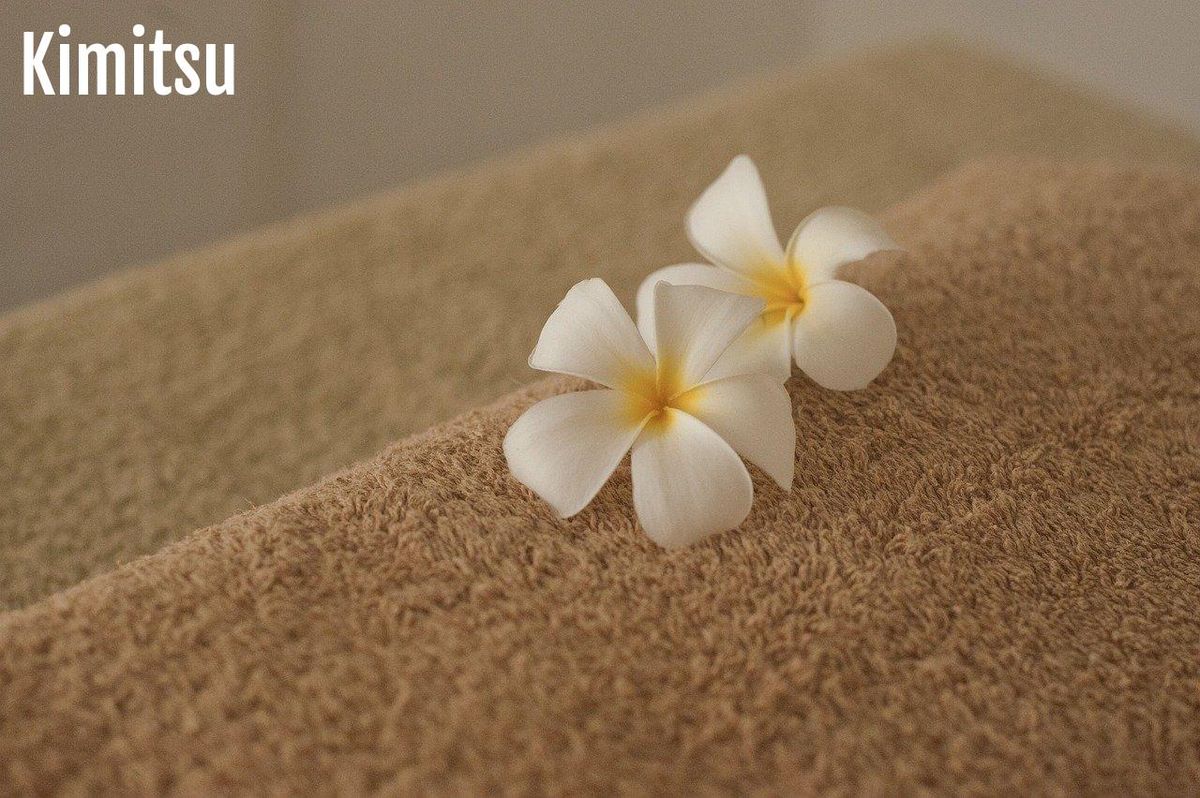 Serviettes et fleurs pour une relaxation douce—le massage apaise l'esprit.