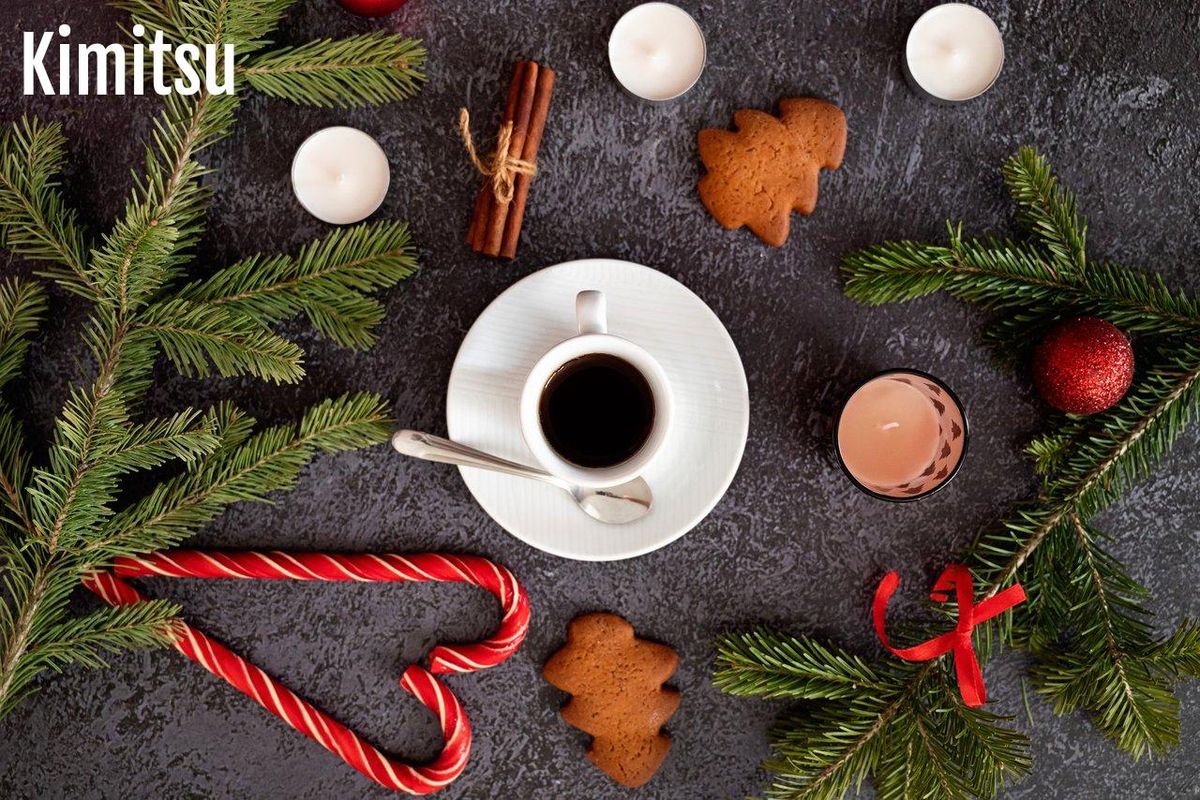 Table festive avec biscuits de Noël, chocolats chauds et bougies pour une ambiance chaleureuse.
