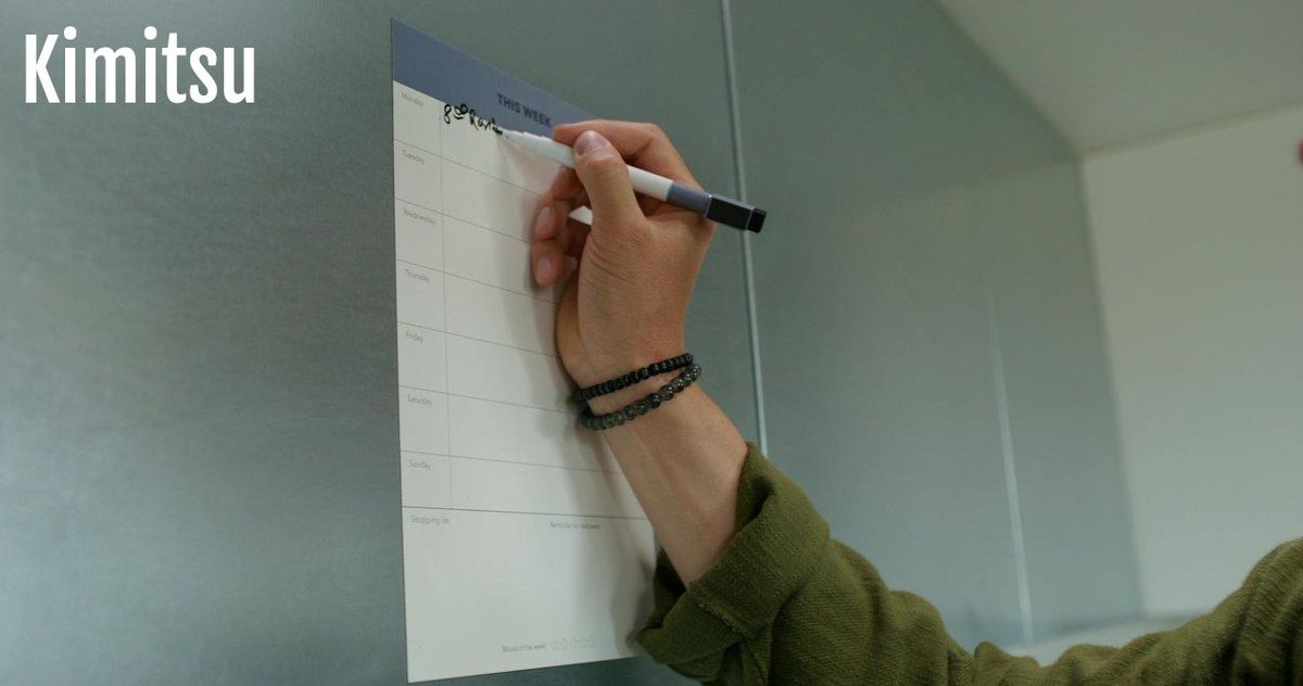 Tableau familial magnétique liège et surface effaçable sur réfrigérateur moderne pour organiser le budget et les tâches.