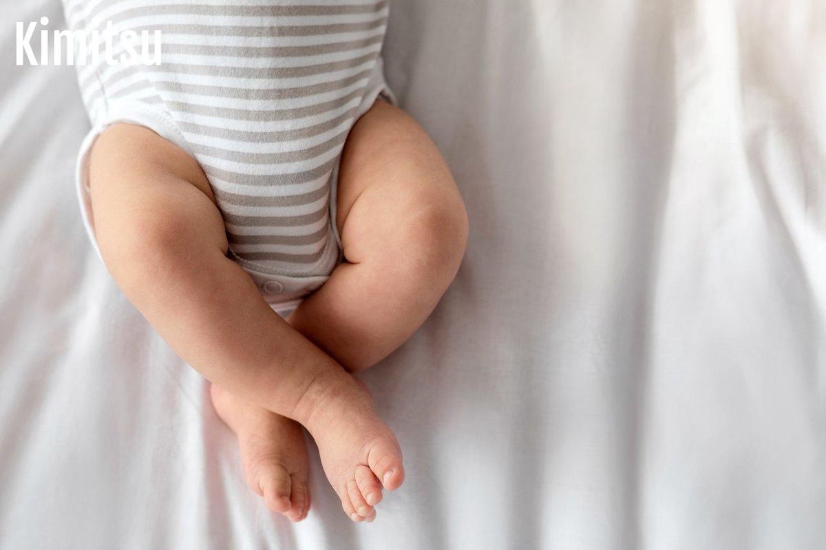 Un bébé dormant paisiblement en couche, pyjama ample et shorty imperméable bien ajusté pour des nuits sèches.