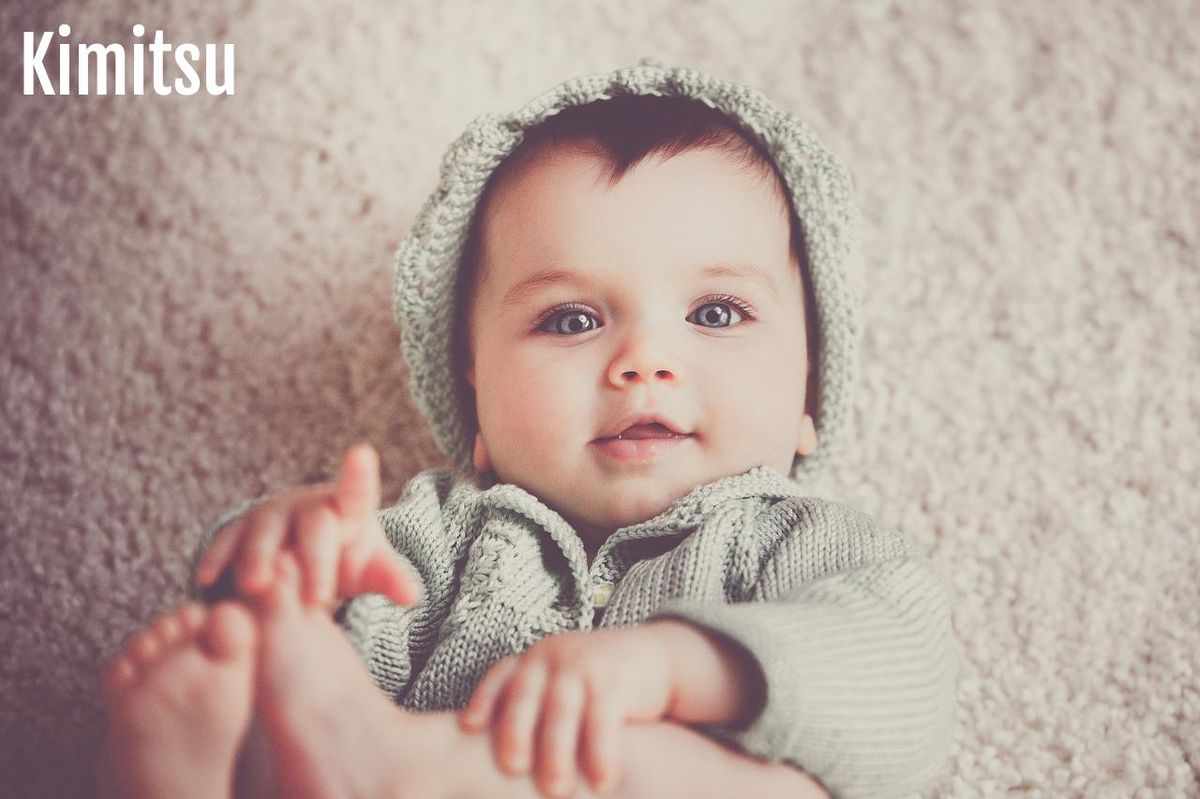 Un bébé explore ses pieds, capturant la magie de découvrir ses sens.