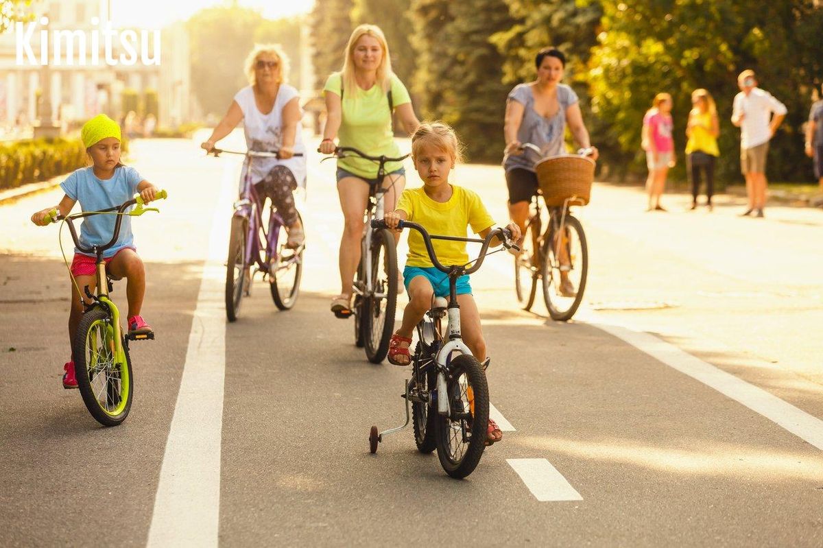 Une famille souriante en balade à vélo dans la campagne verdoyante, idéale pour une sortie familiale à vélo.
