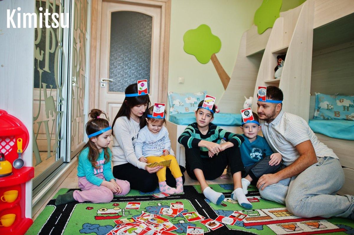 Une famille souriante jouant à un jeu de société dynamique, renforçant le lien familial avec du fun et des rires.