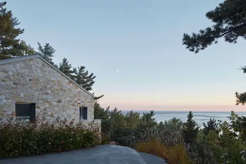 Une maison en pierre construite sur une falaise rocheuse au bord du précipice