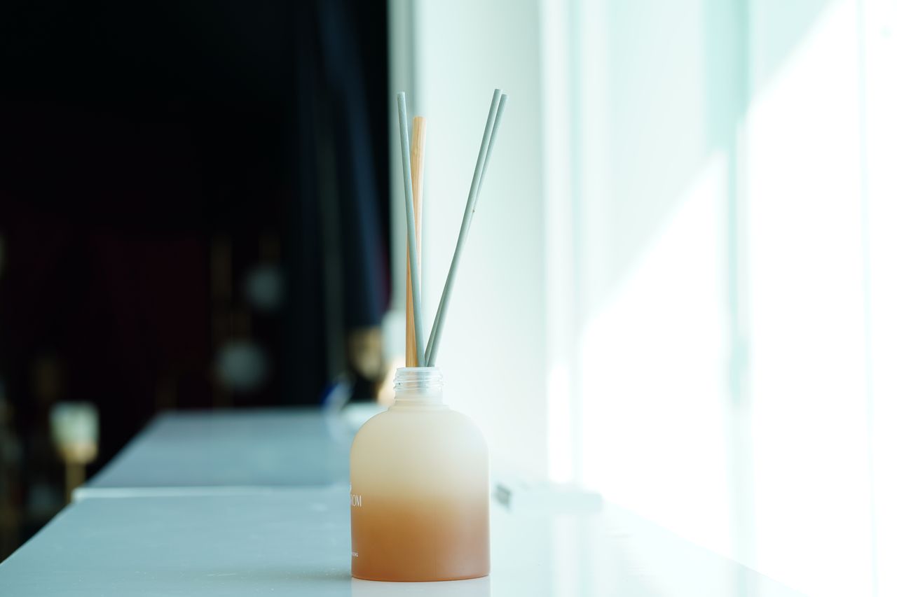 Diffuseurs d’huiles essentielles en verre, plâtre et argile sur table claire, ambiance zen et décor raffiné.