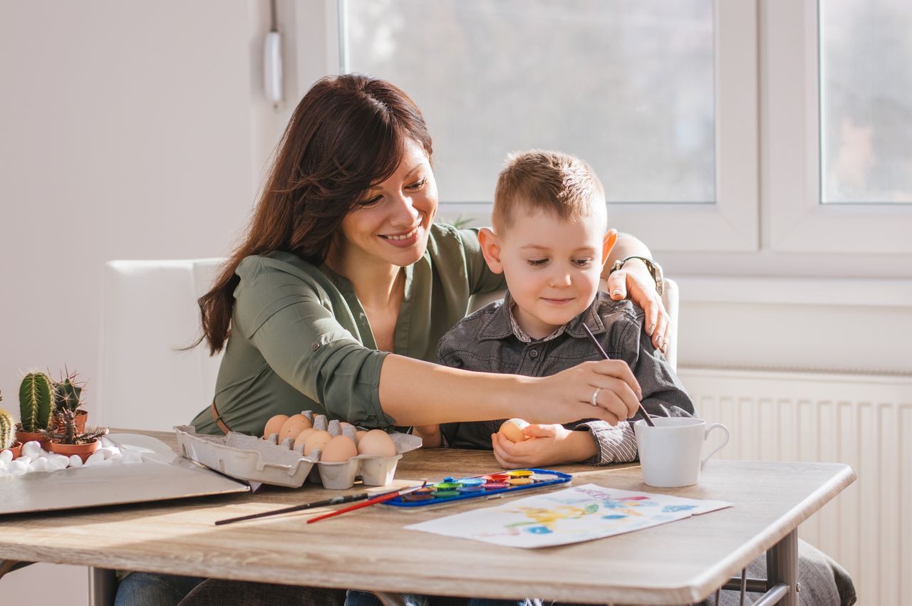 Enfant et parent réalisent une expérience scientifique colorée à la maison avec du matériel simple