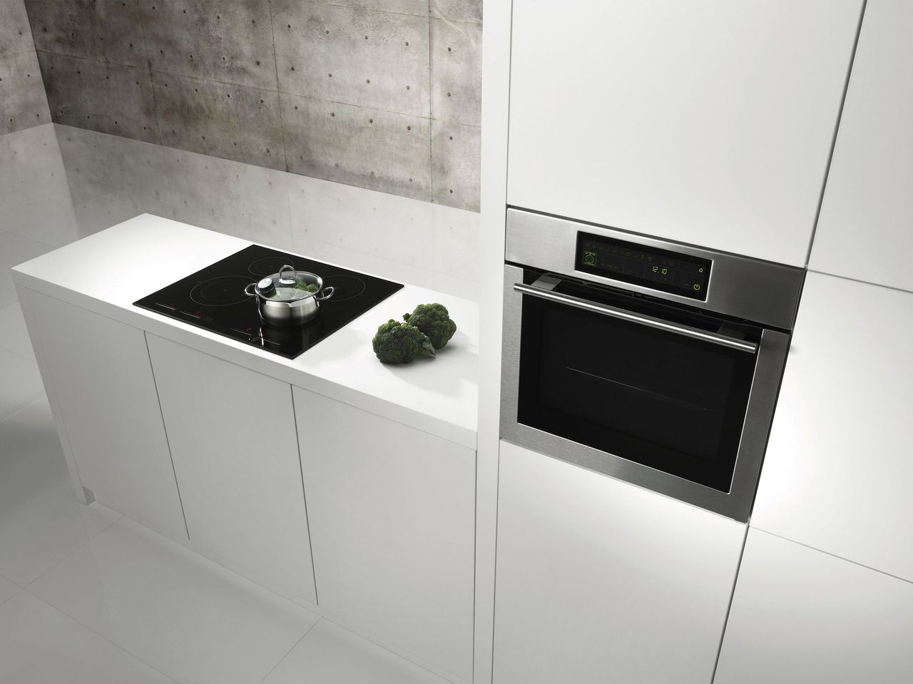 Four électrique encastré et plaque à induction modernes dans une cuisine blanche design et fonctionnelle
