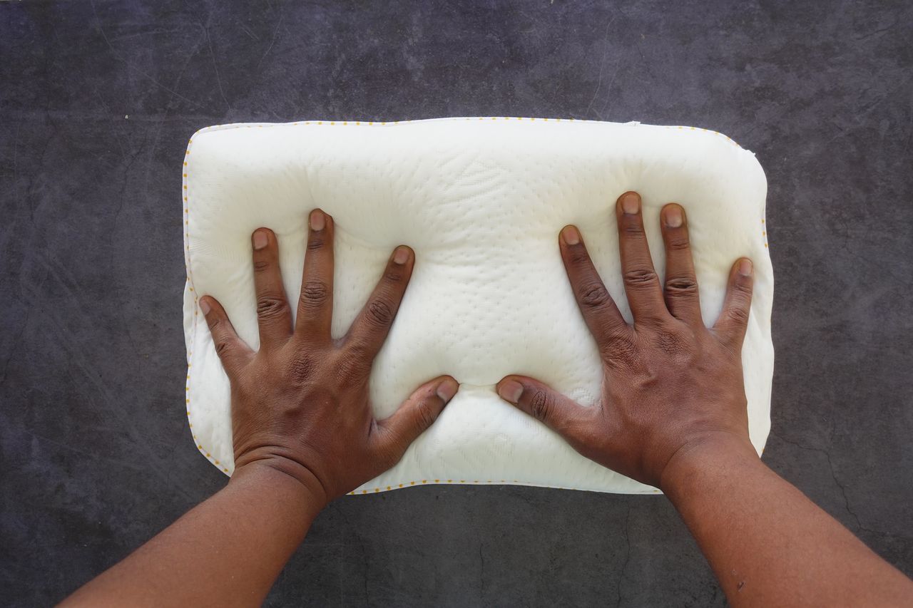 Oreillers ergonomiques en mousse à mémoire de forme et latex sur un lit clair, confort optimal.