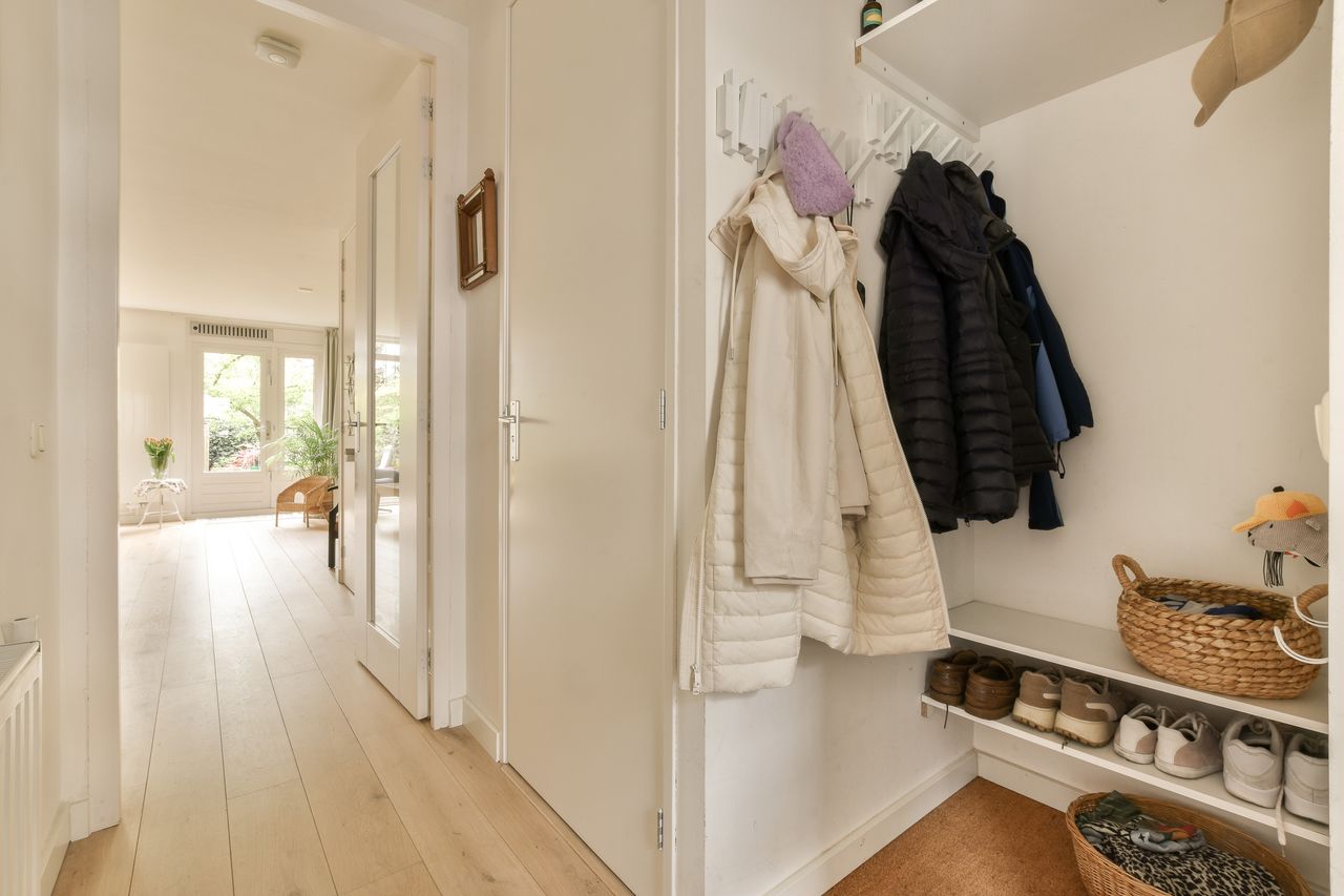 Range-chaussures mural en bois clair dans une petite entrée étroite, pratique et élégant pour gagner de la place.