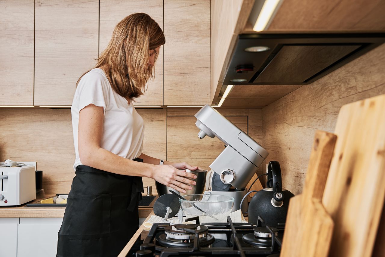 Robot cuiseur Magimix sur plan de travail familial, avec légumes frais et bol inox.