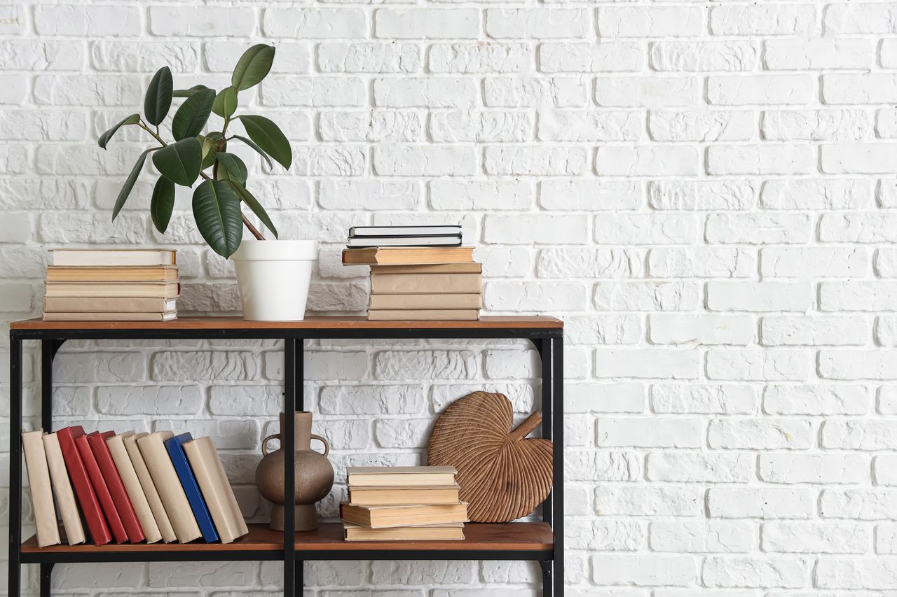 Salon rustique chic avec mur en bois patiné, briques apparentes, bibliothèque décorative et lettres en bois.