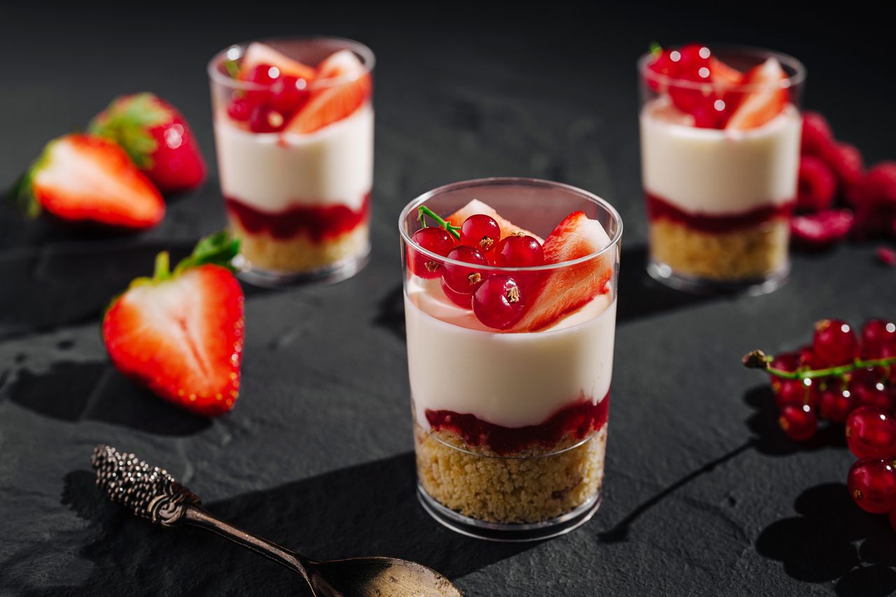 Table de desserts d’été fraîches avec fraises, framboises, citron et verrines colorées gourmandes.