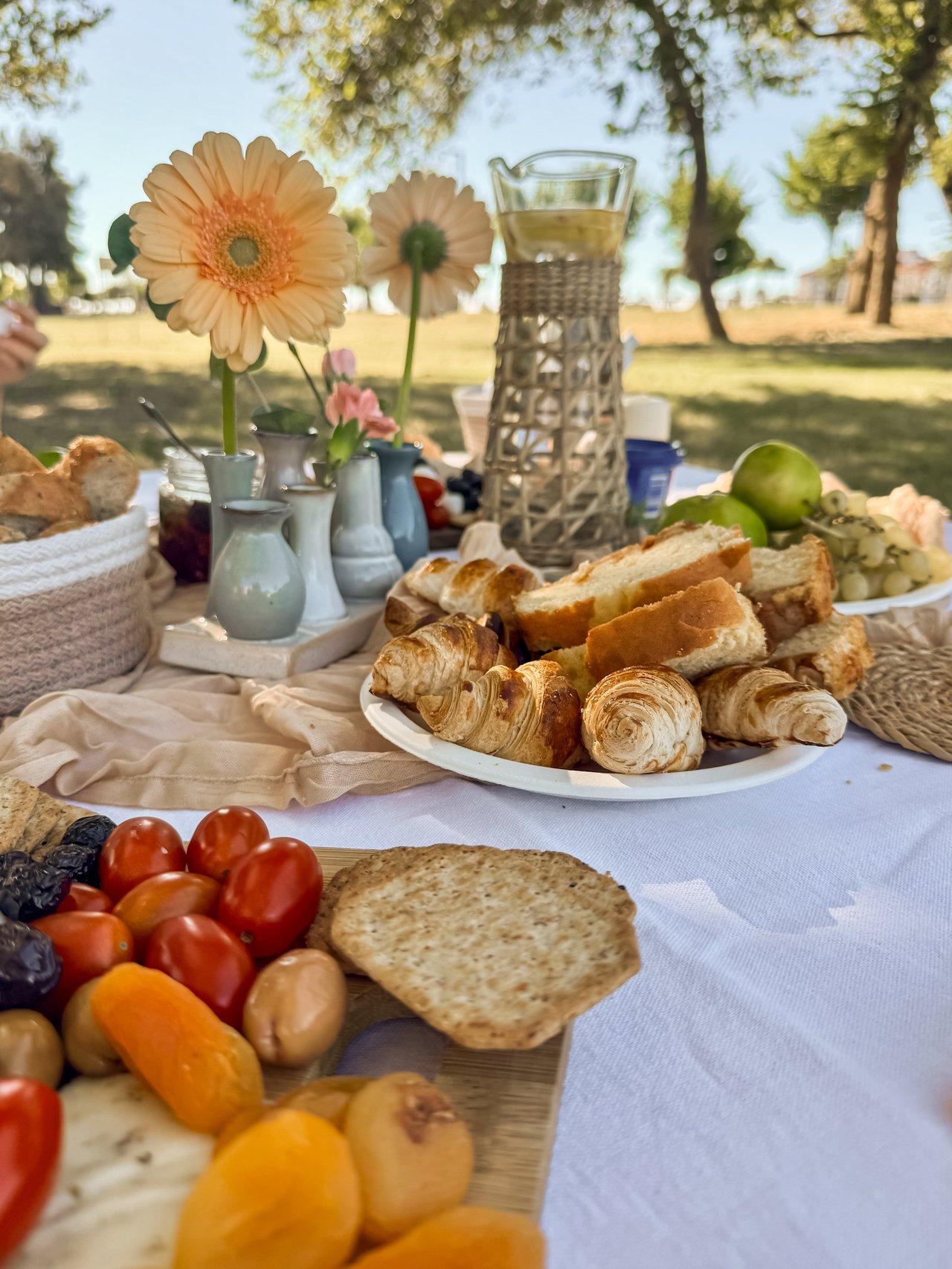 Un spring picnic platter coloré avec fruits frais, pain et pâtisseries en plein air.