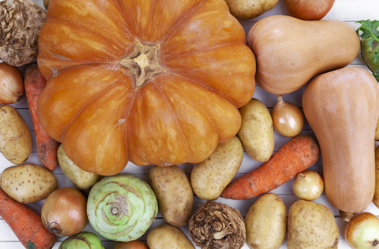 Épluchures d’automne triées avec bocaux, plaque de four et légumes de saison sur table en bois الأبيض