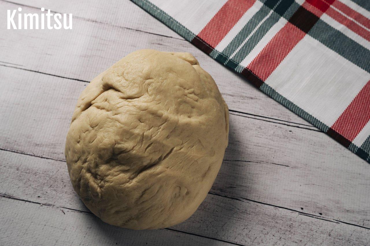 Pâte à pizza maison bien levée et alvéolée, prête à être étalée pour une pizza croustillante et moelleuse.