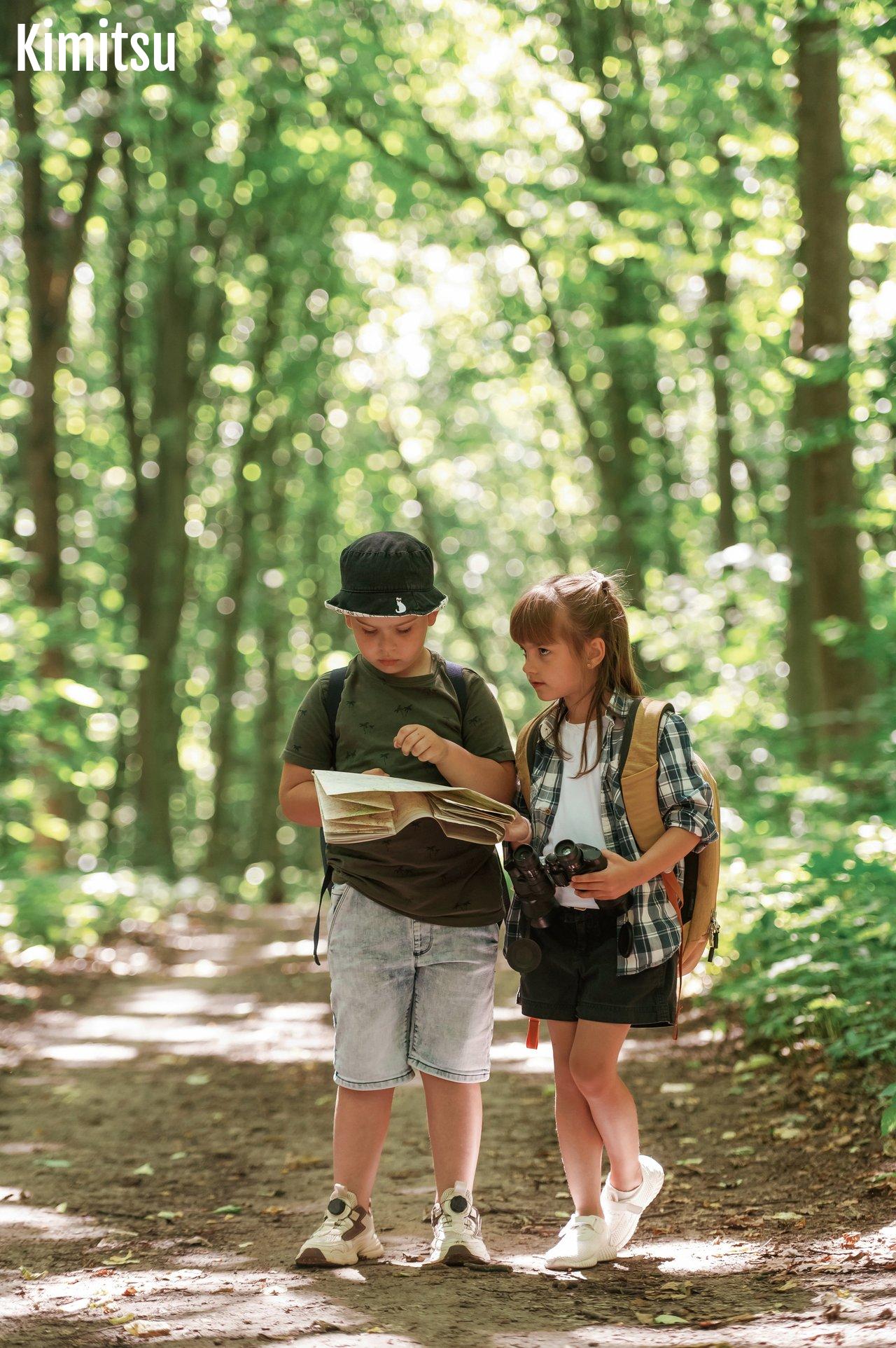 Une famille en forêt participe à une treasure hunt, découvrant le chemin avec une carte lors d'une aventure estivale.